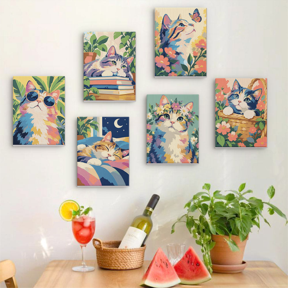 Six finished Cats in Bloom mini paintings hung on a wall above a table