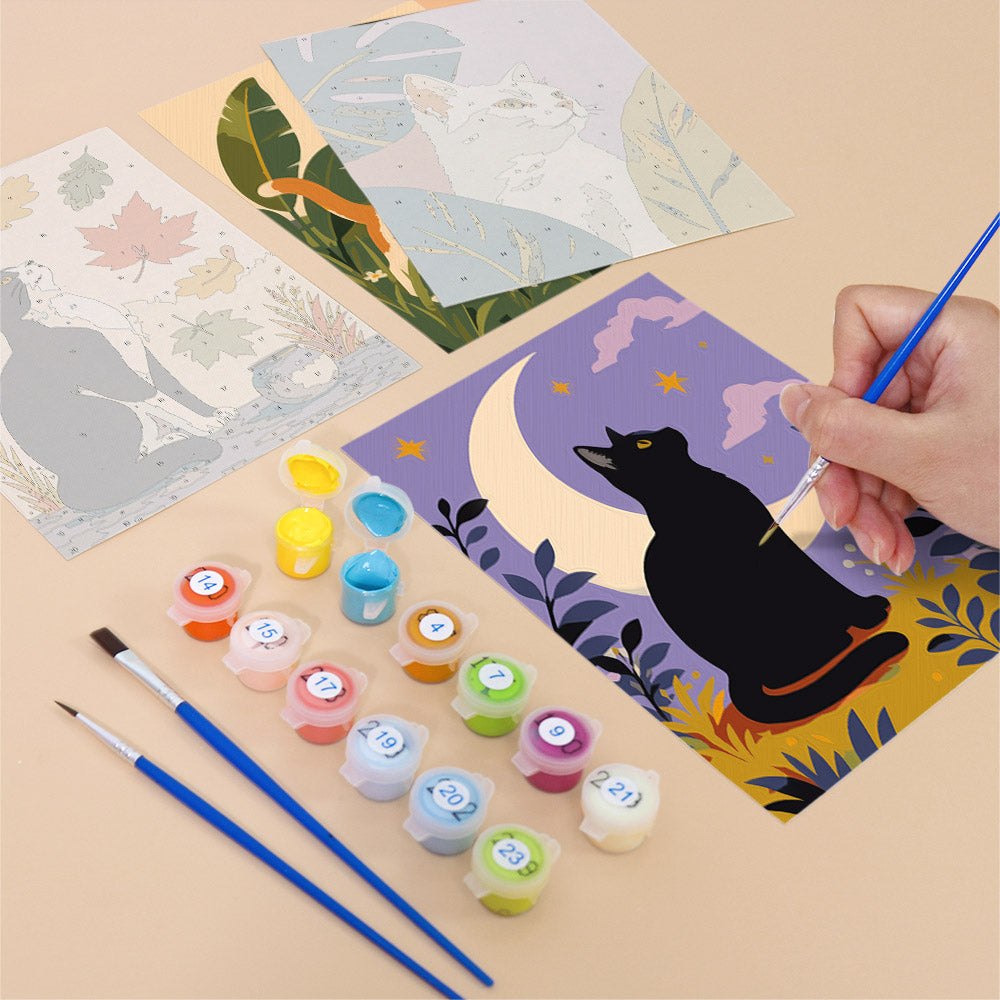 Filling in a Cats Through the Seasons mini canvas with numbered acrylic paints and a fine brush