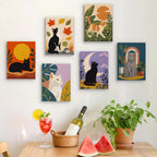 Six finished Cats Through the Seasons mini paintings hung on a wall above a table