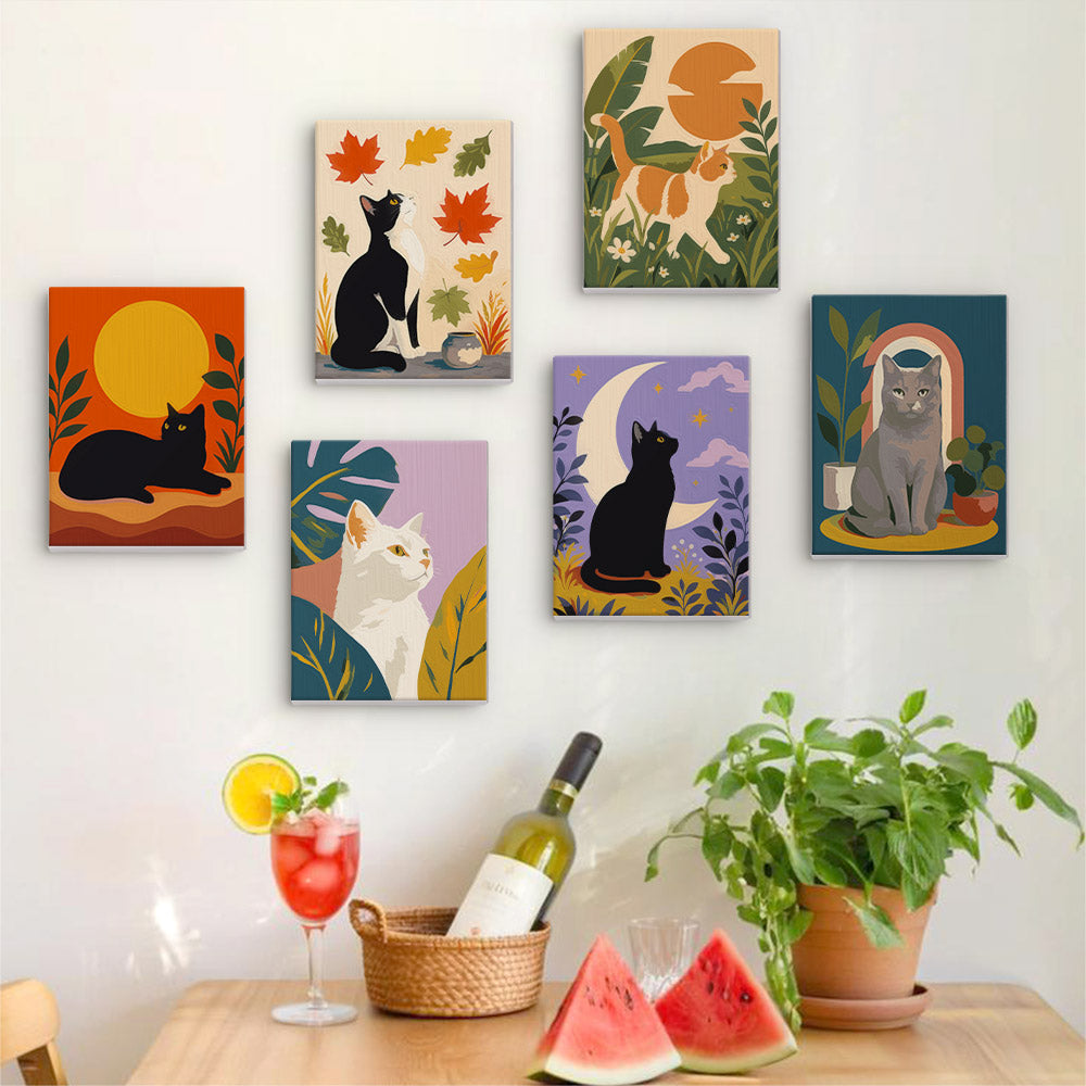 Six finished Cats Through the Seasons mini paintings hung on a wall above a table