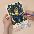 Hand holding a Celestial Cards mini canvas while painting the details