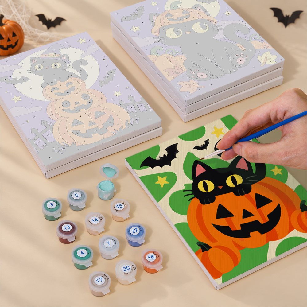 Painting one of the Checkered Cat Pumpkins designs next to a stack of mini canvases