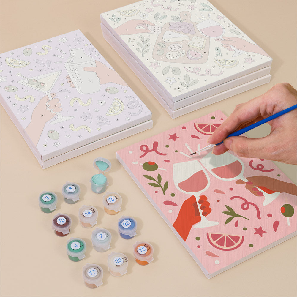 Painting one of the Cheers and Treats designs next to a stack of mini canvases