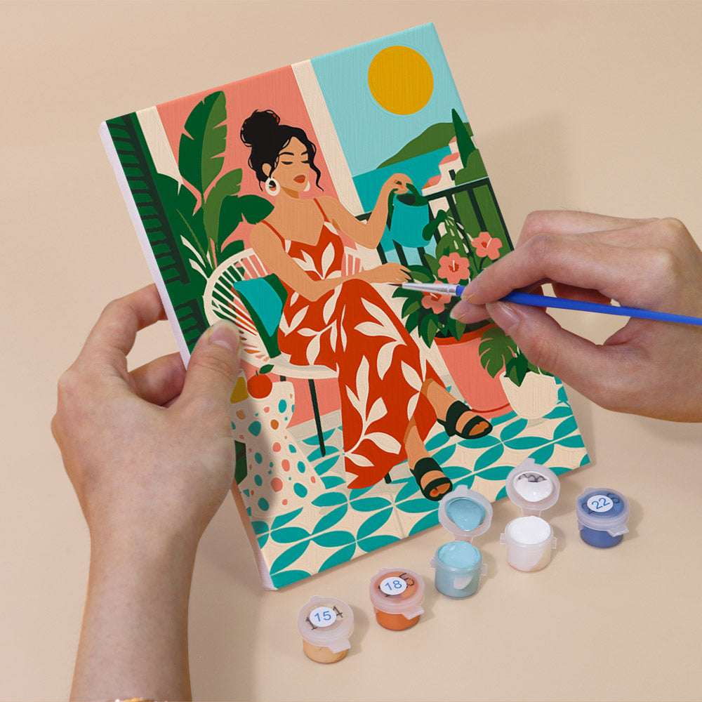 Hand holding a Chic at Home mini canvas while painting the details
