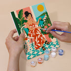 Hand holding a Chic at Home mini canvas while painting the details