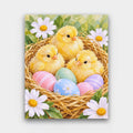 Chicks in the Nest paint by numbers kit of three fluffy yellow chicks in a straw nest with pastel Easter eggs and daisies