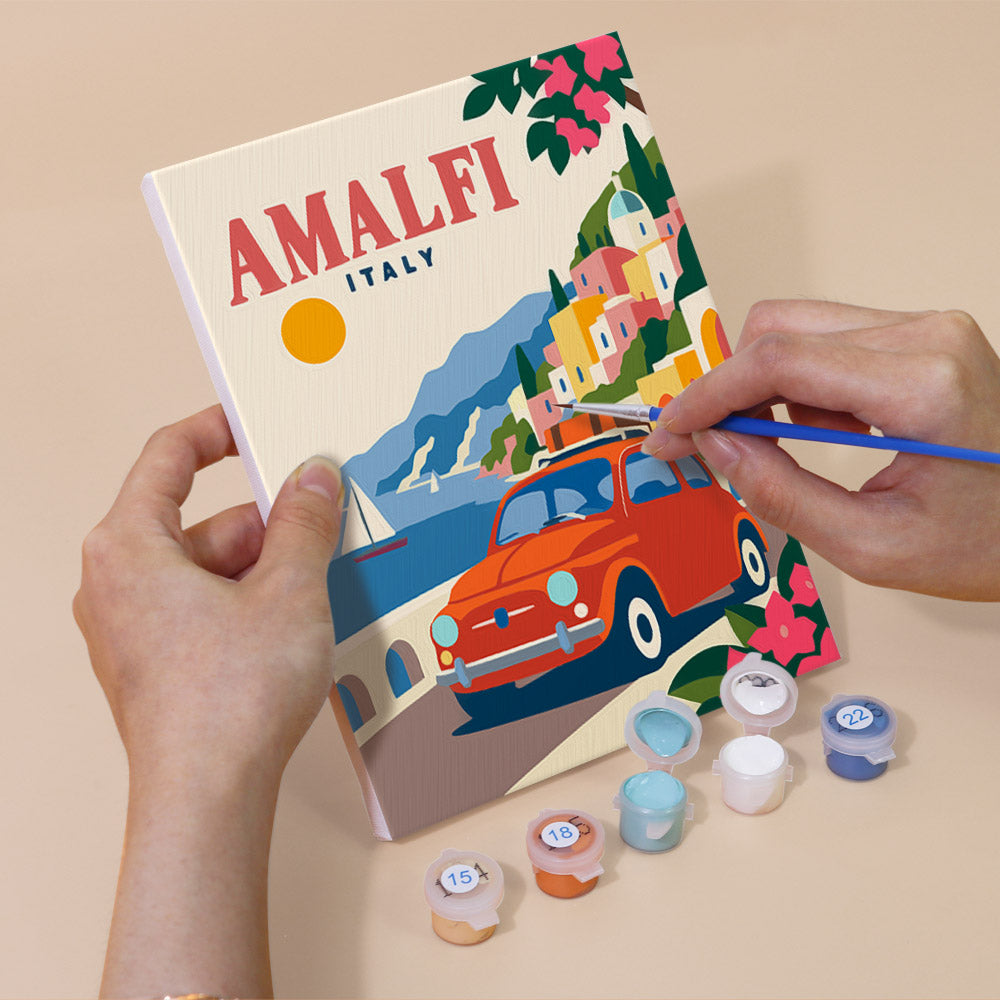 Hand holding a Classic Car Getaways mini canvas while painting the details