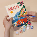 Hand holding a Classic Car Getaways mini canvas while painting the details