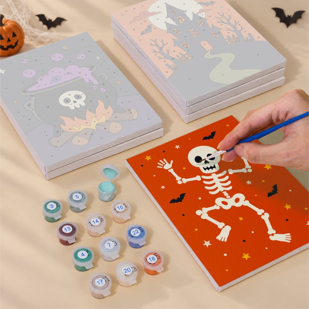 Painting one of the Classic Halloween designs next to a stack of mini canvases