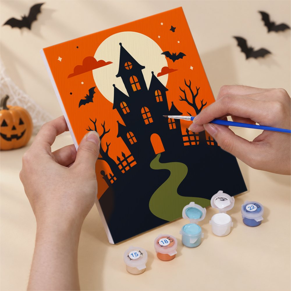 Hand holding a Classic Halloween mini canvas while painting the details