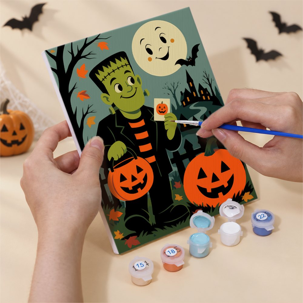 Hand holding a Classic Monster Moon mini canvas while painting the details