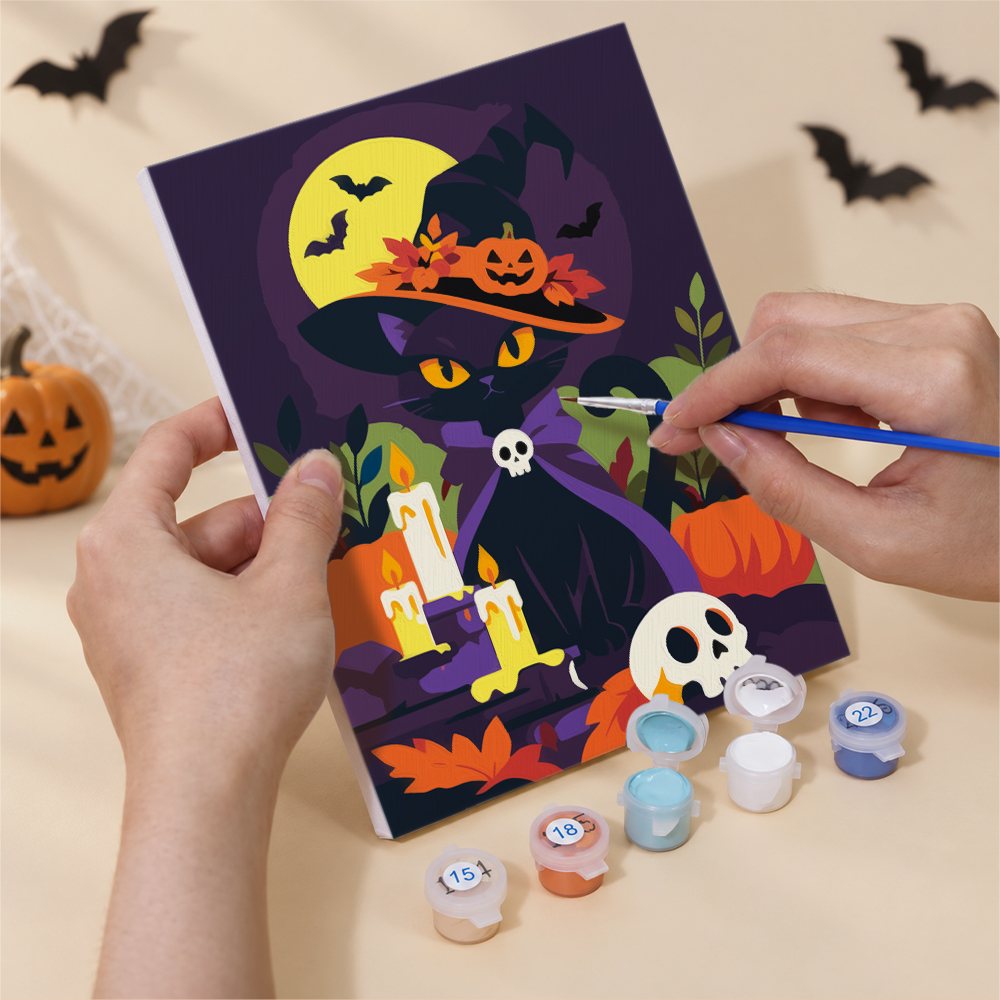 Hand holding a Classic Spooky Nights mini canvas while painting the details