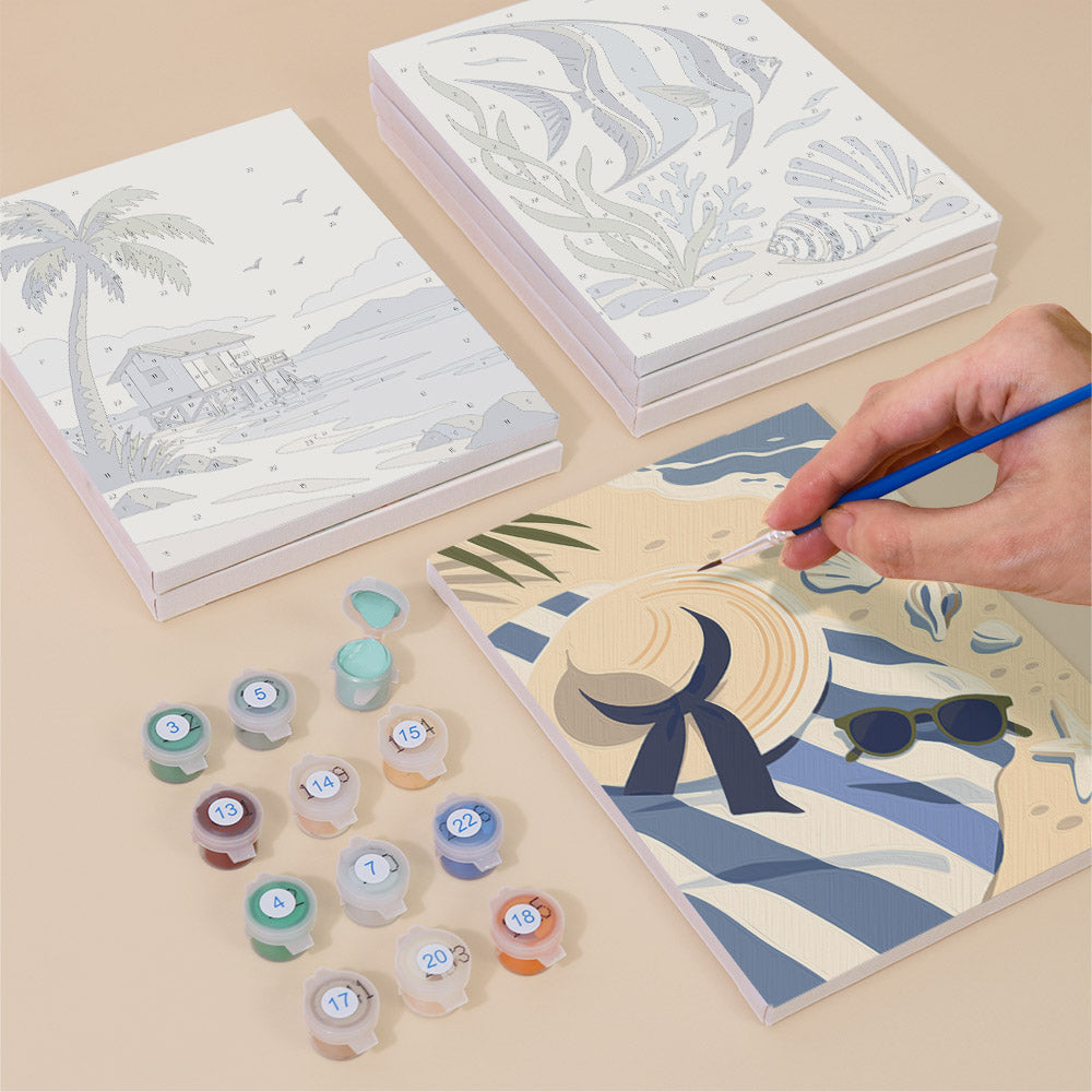 Painting one of the Coastal Blues designs next to a stack of mini canvases