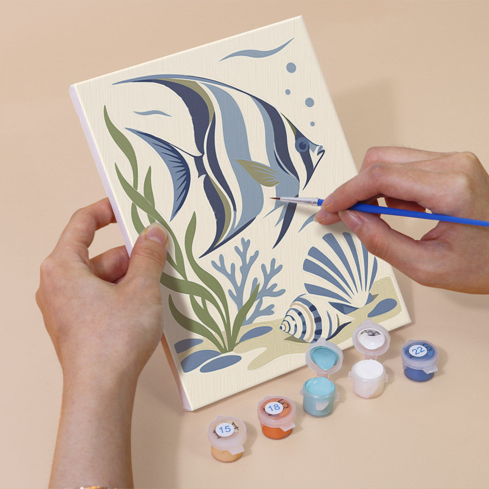 Hand holding a Coastal Blues mini canvas while painting the details