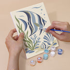 Hand holding a Coastal Blues mini canvas while painting the details