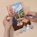 Hand holding a Coastal Breakfast mini canvas while painting the details