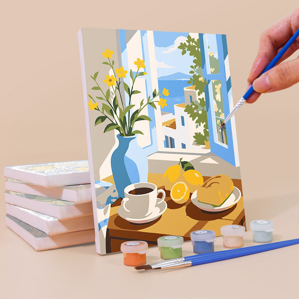 Painting a Coastal Breakfast mini canvas propped up beside numbered acrylic paints