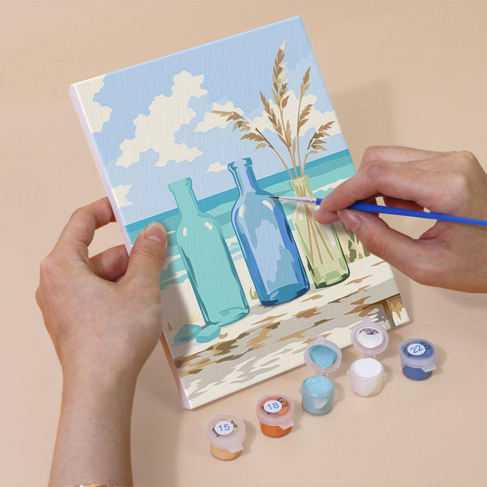 Hand holding a Coastal Whites mini canvas while painting the details