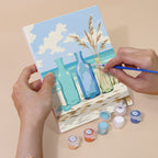 Hand holding a Coastal Whites mini canvas while painting the details