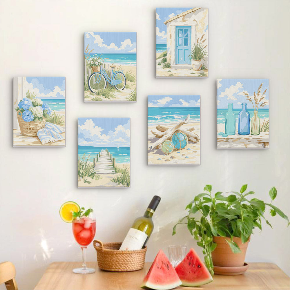 Six finished Coastal Whites mini paintings hung on a wall above a table