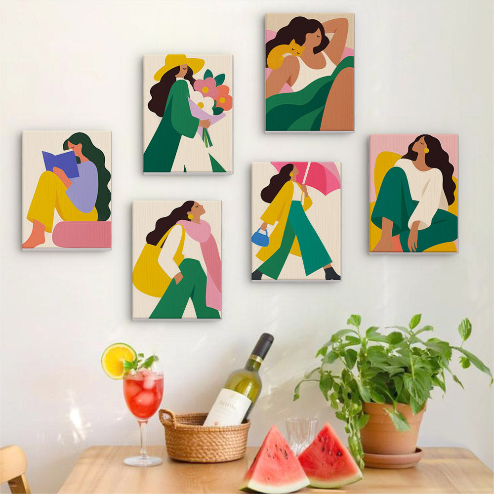 Six finished Color Block Ladies mini paintings hung on a wall above a table
