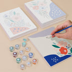 Painting one of the Confetti Petals designs next to a stack of mini canvases