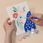 Hand holding a Confetti Petals mini canvas while painting the details