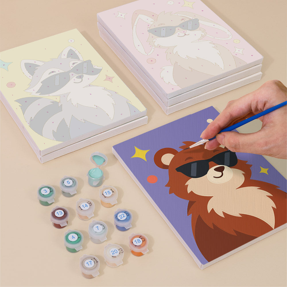 Painting one of the Cool Critters designs next to a stack of mini canvases