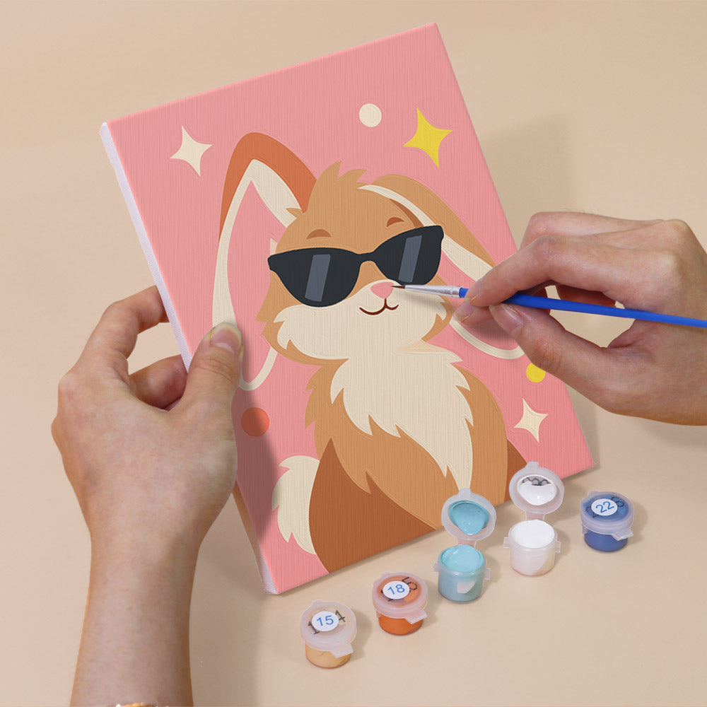 Hand holding a Cool Critters mini canvas while painting the details