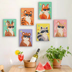 Six finished Cool Critters mini paintings hung on a wall above a table