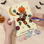 Hand holding a Cosmic Costume Characters mini canvas while painting the details