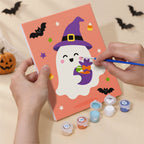 Hand holding a Costume Cuties mini canvas while painting the details