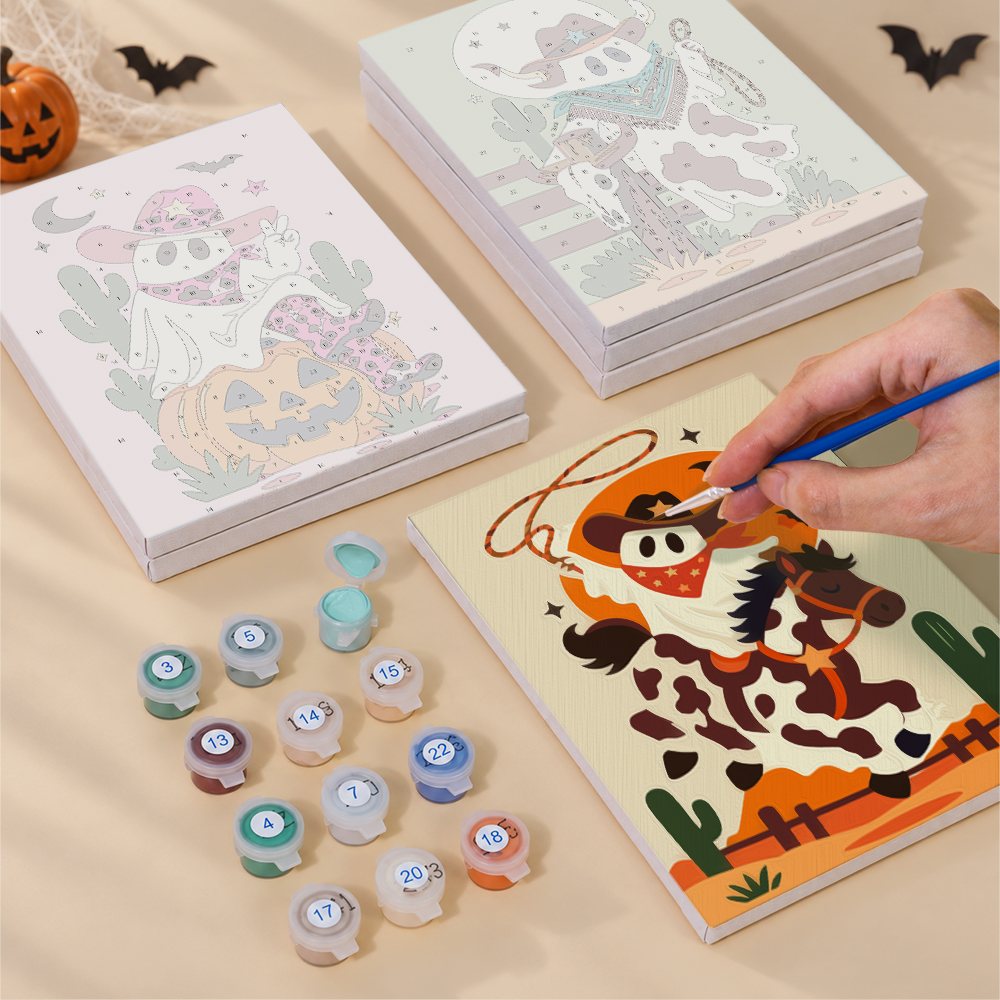 Painting one of the Cowboy Ghost Ranch designs next to a stack of mini canvases