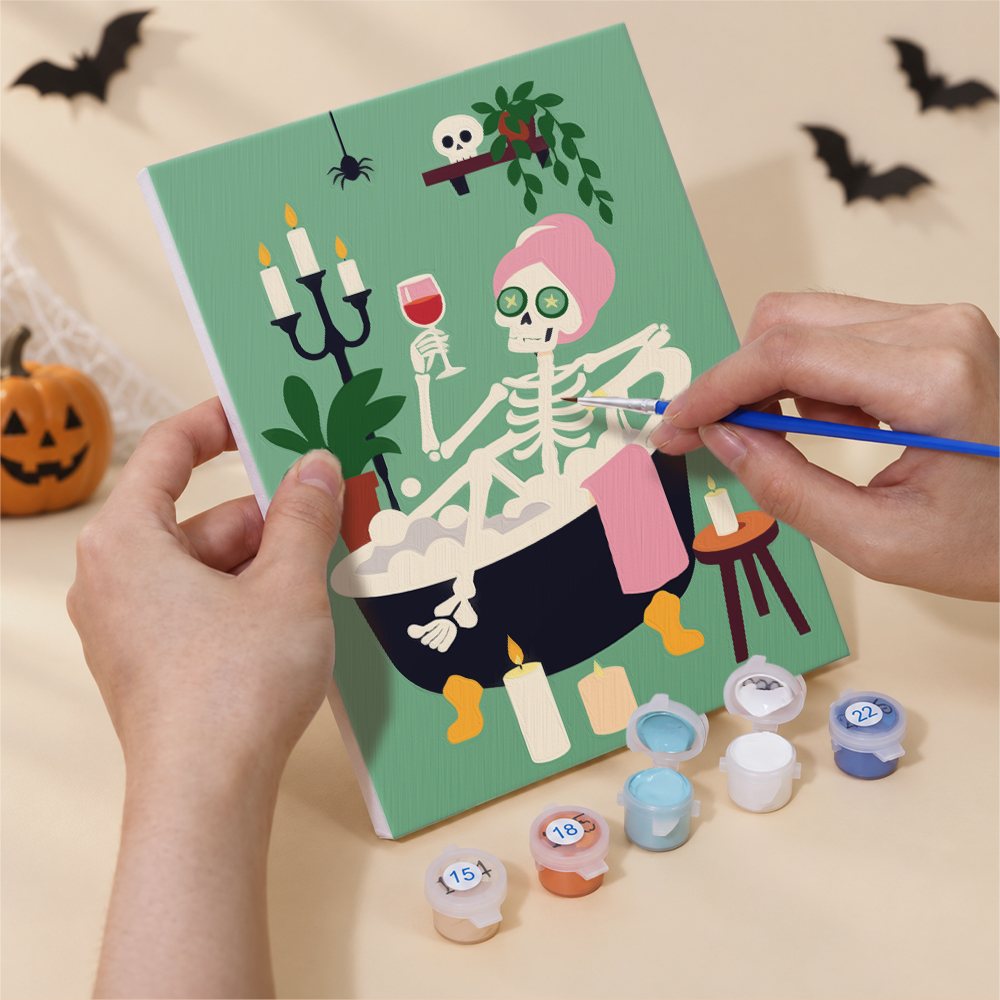 Hand holding a Cozy Autumn Spooks mini canvas while painting the details