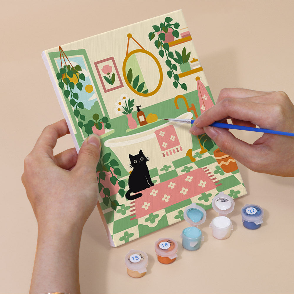 Hand holding a Cozy Cat Home mini canvas while painting the details