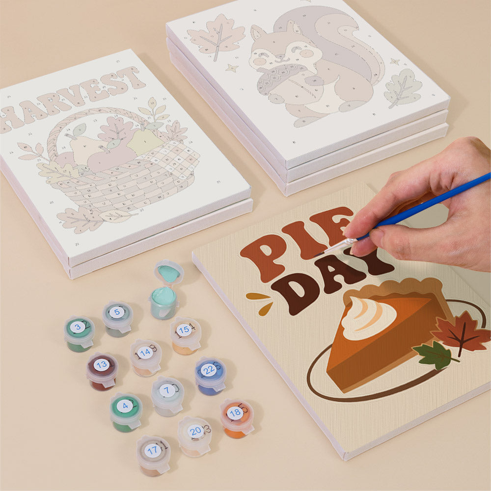 Painting one of the Cozy Fall designs next to a stack of mini canvases
