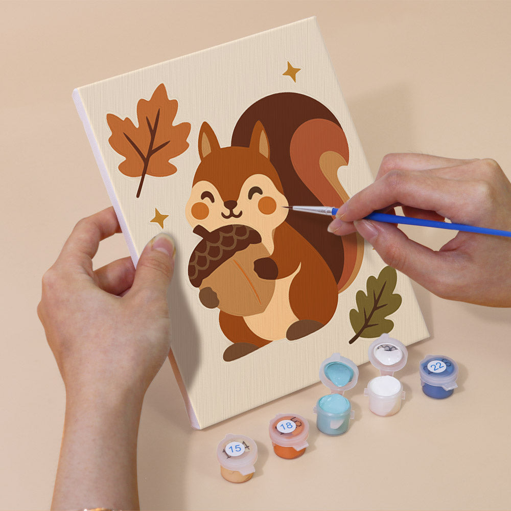 Hand holding a Cozy Fall mini canvas while painting the details
