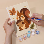 Hand holding a Cozy Fall mini canvas while painting the details