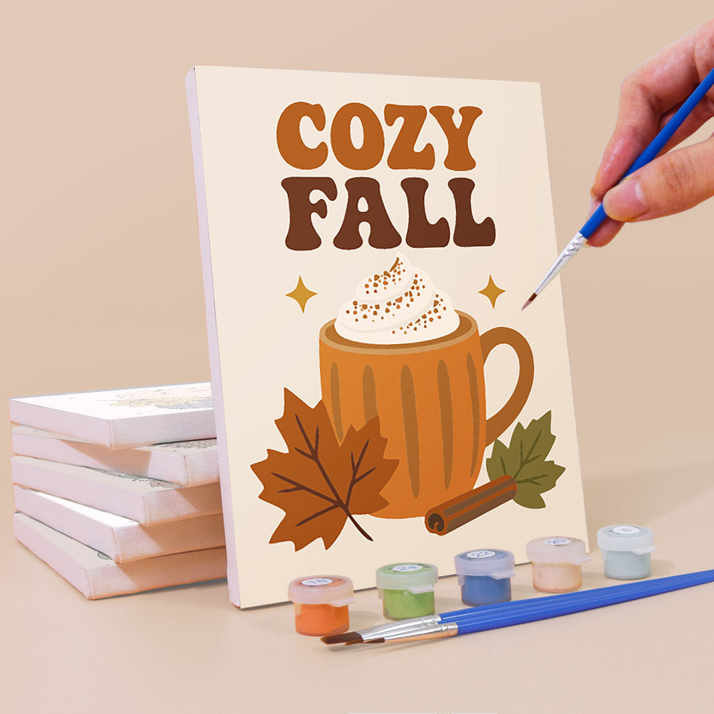 Painting a Cozy Fall mini canvas propped up beside numbered acrylic paints