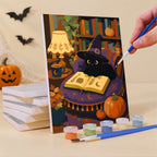 Painting a Cozy Witch Cottage mini canvas propped up beside numbered acrylic paints