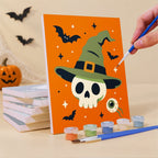 Painting a Creepy Classics mini canvas propped up beside numbered acrylic paints