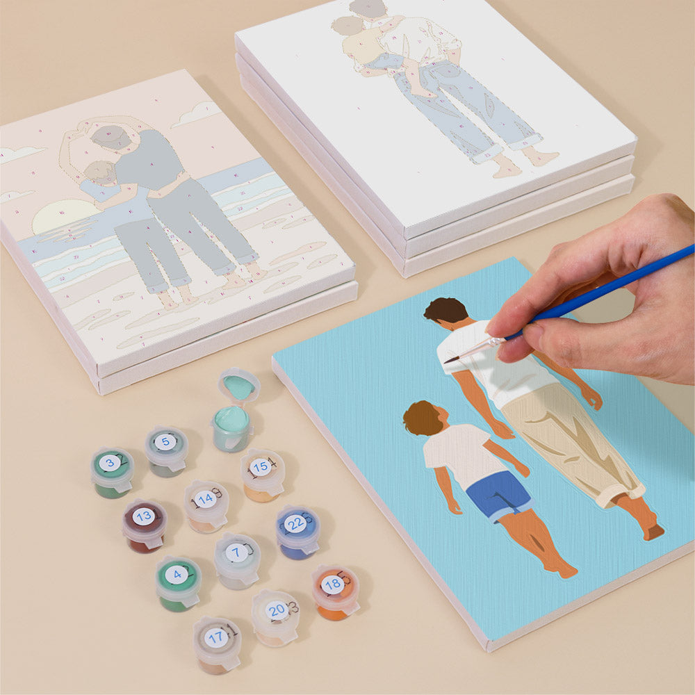 Painting one of the Dad and Me designs next to a stack of mini canvases