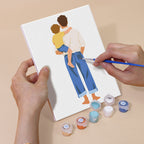 Hand holding a Dad and Me mini canvas while painting the details