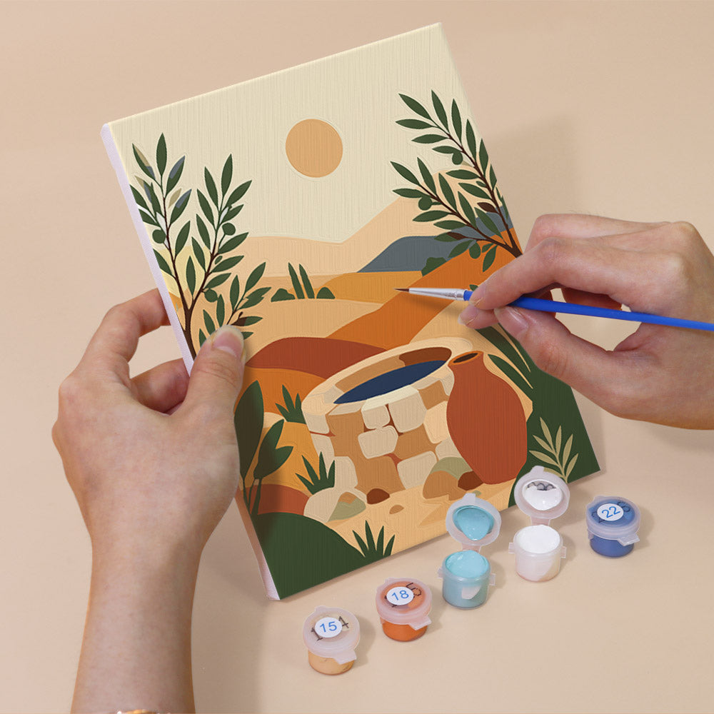 Hand holding a Desert Light mini canvas while painting the details