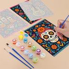 Filling in a Día de Muertos mini canvas with numbered acrylic paints and a fine brush