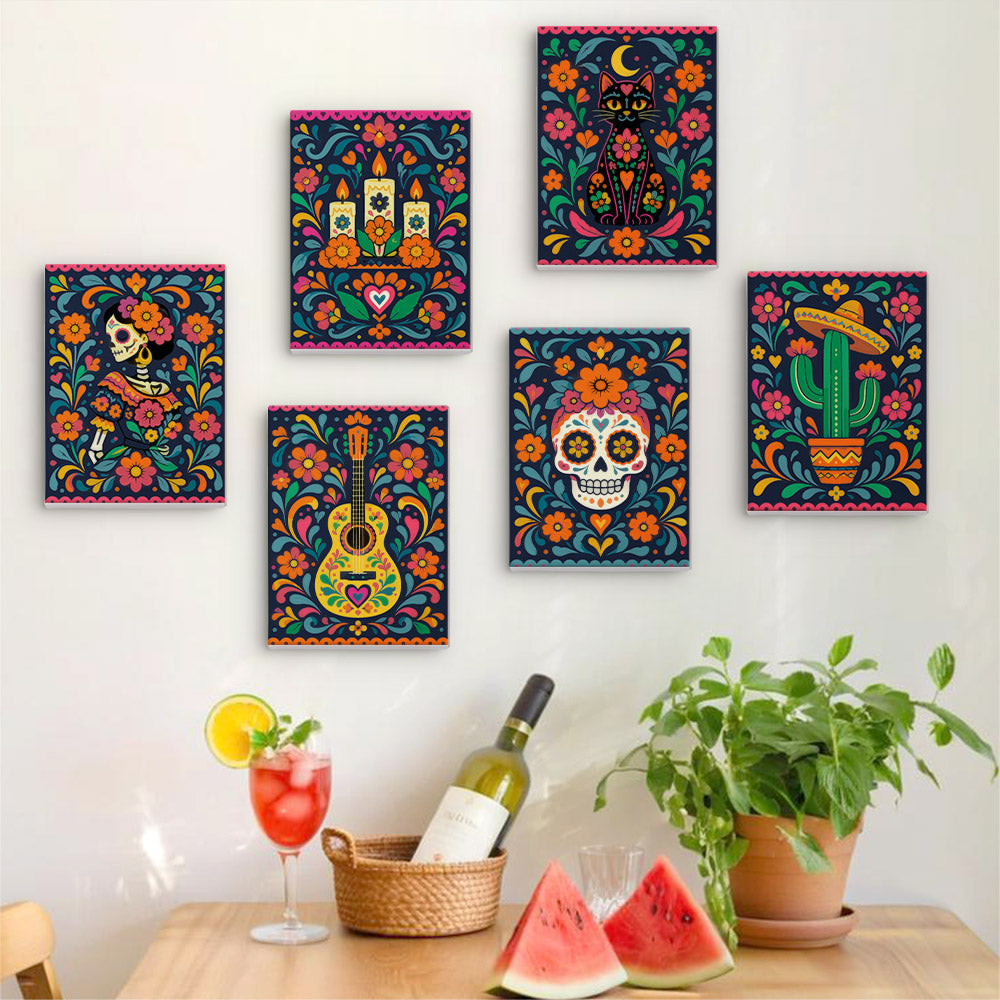 Six finished Día de Muertos mini paintings hung on a wall above a table