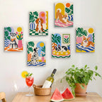 Six finished Dogs at Home mini paintings hung on a wall above a table