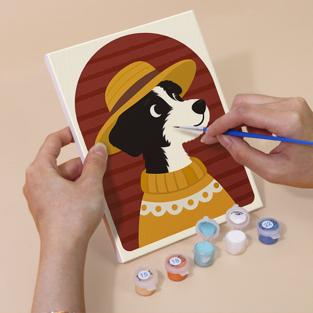 Hand holding a Dogs in Sweaters mini canvas while painting the details