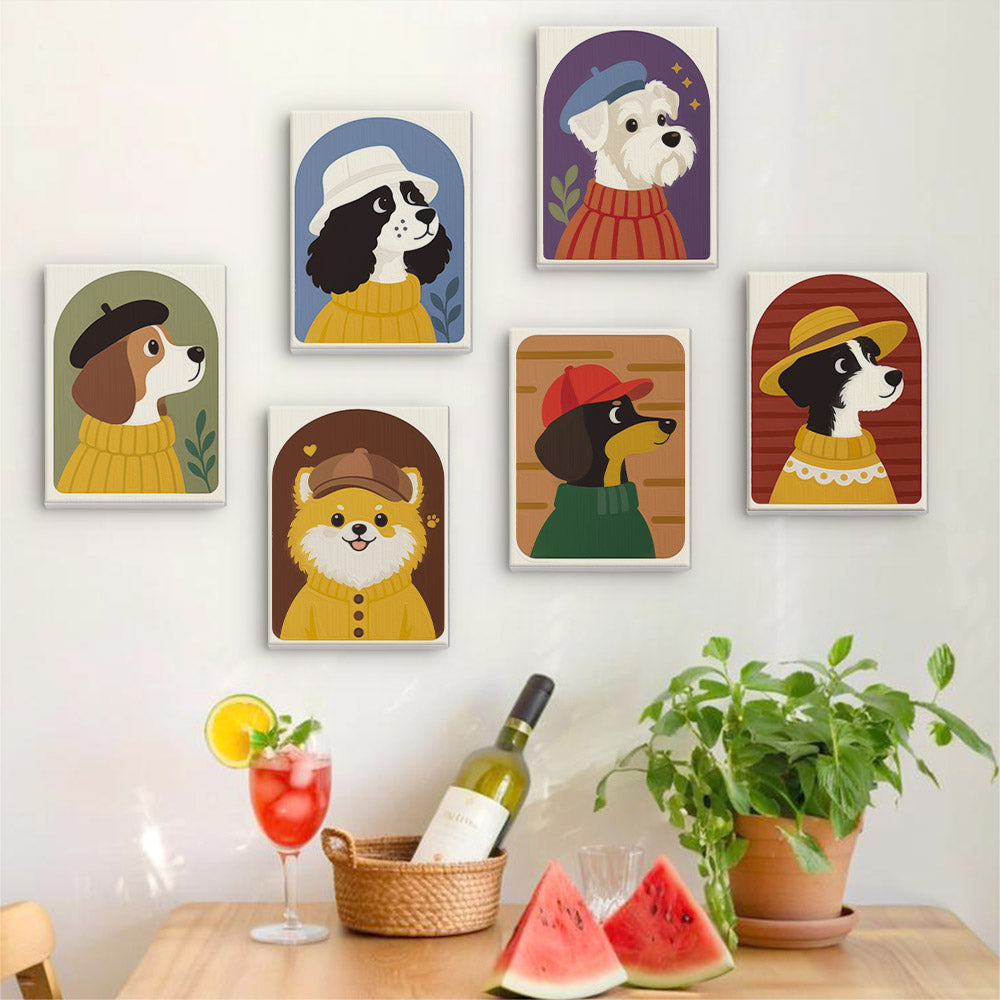 Six finished Dogs in Sweaters mini paintings hung on a wall above a table