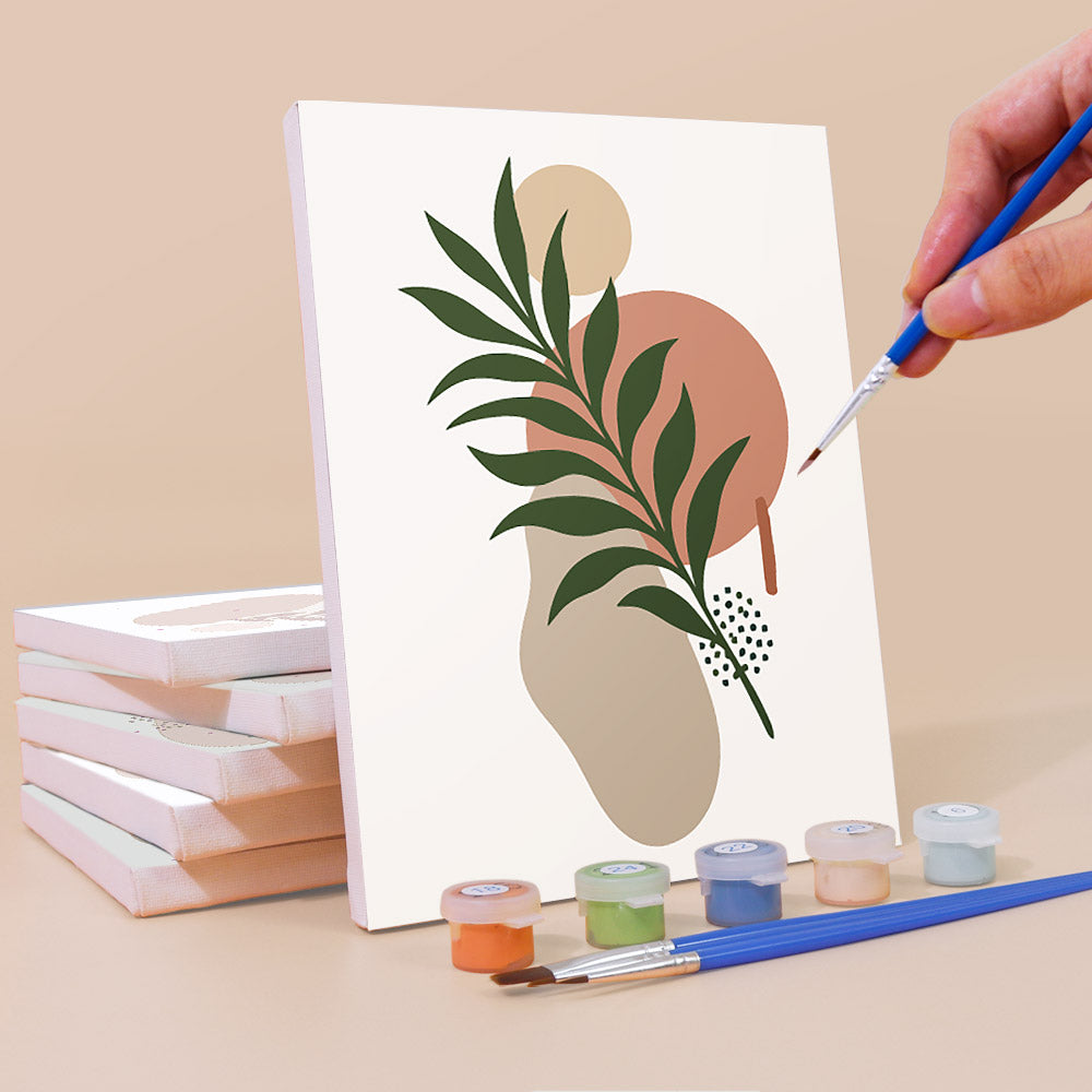 Painting an Earthy Leaves mini canvas propped up beside numbered acrylic paints